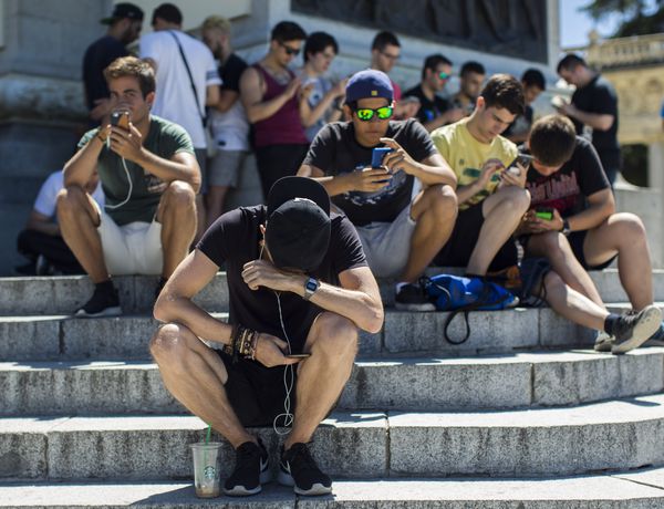 Teenagers with mobile phones at the Estanque del Retiro in Madrid.